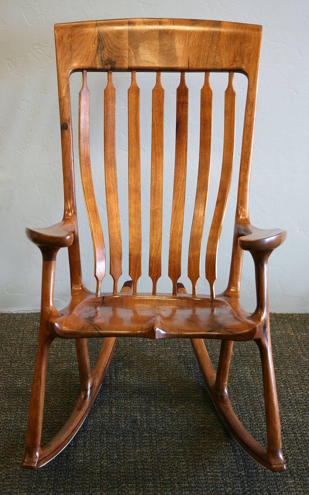 This is a handcrafted rocking chair made by Landon Sanborn. It is the product of over 500 man hours, and he only makes about one chair per year. The back rails are made of ashwood to give flexibility and comfort. The rocker runners are made of
