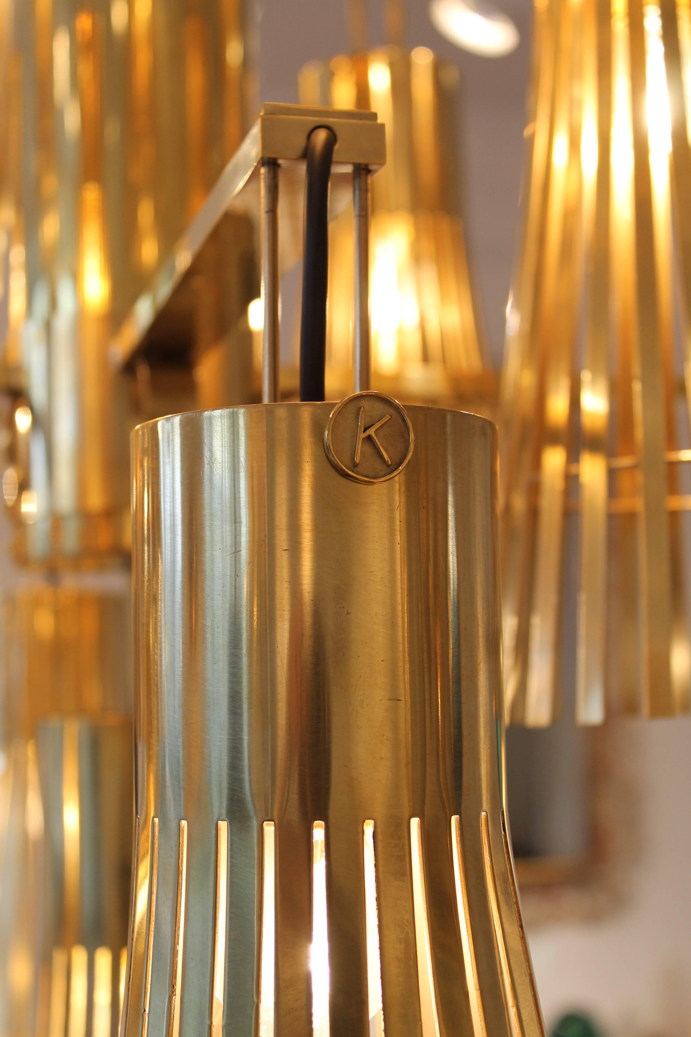 Kam Tin
golden chandelier in brass.
Measures: Height 138 cm circa; diameter 75 cm circa.
Stamped Kam Tin.
Unique copy,
France, 2015.
 