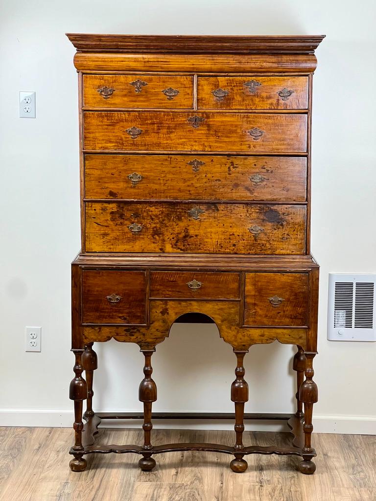 Step back in time with this Antique William & Mary highboy from the early 18th century, a true testament to the craftsmanship and style of its era. Constructed from rich, deeply patinated wood, this highboy features intricate brass pulls on each of