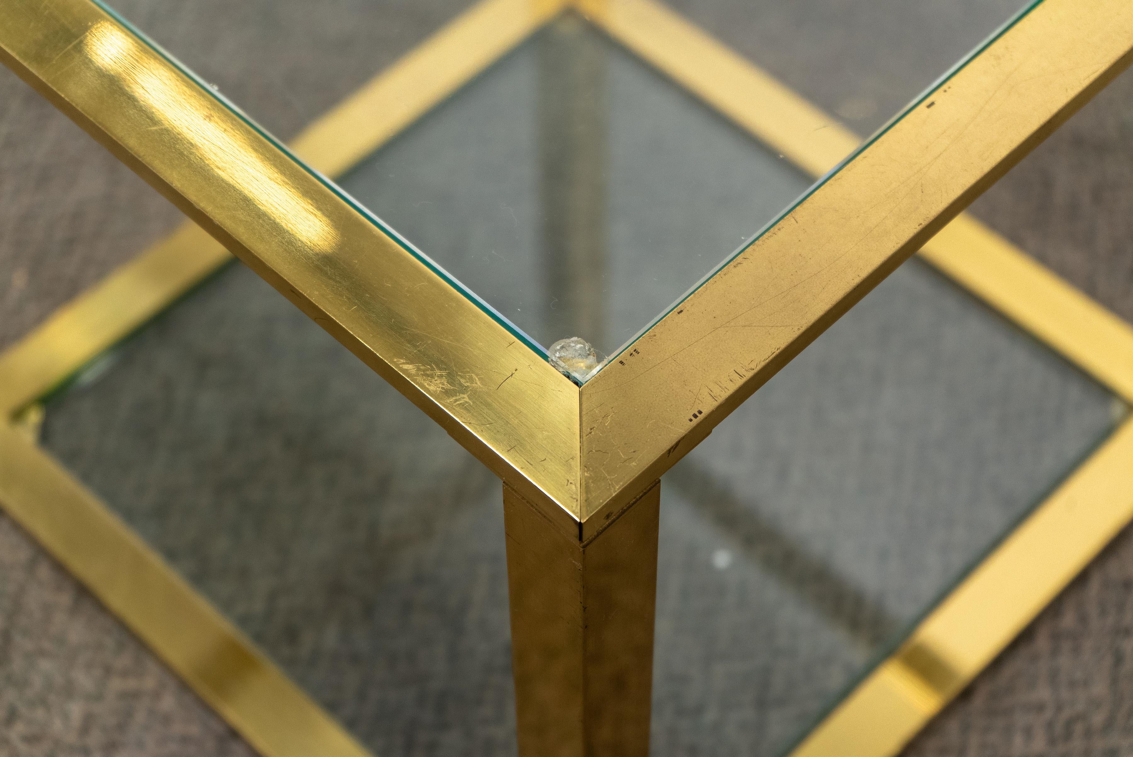 Pair of vintage double layered cantilevered glass and brass tables.