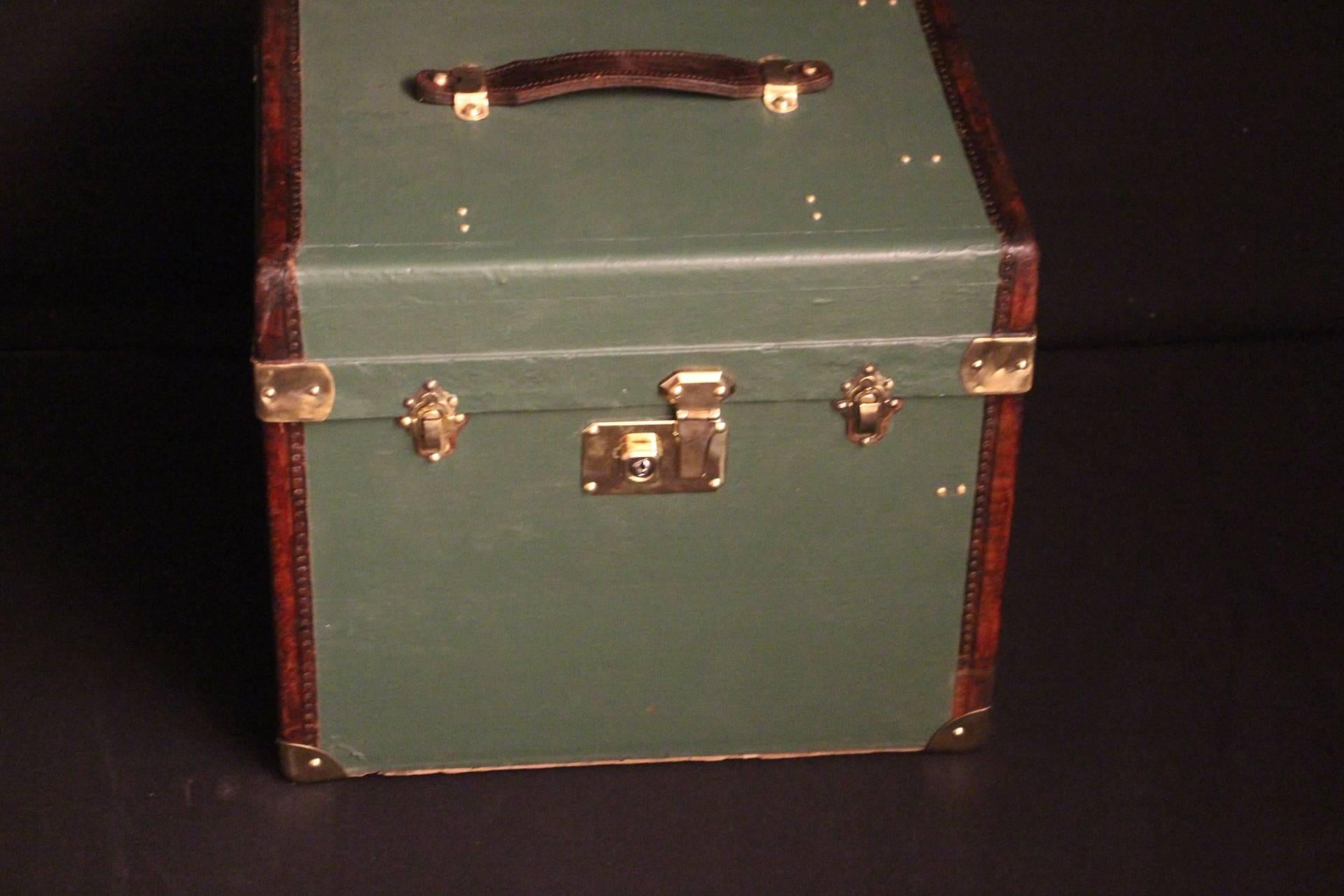 Very nice green canvas hat box featuring brass loxks and corners,leather trim and leather top handle.
Inside relined in beige canvas,very clean,no smell.Perfect for storage.
It could be used as a side table or as a night stand.