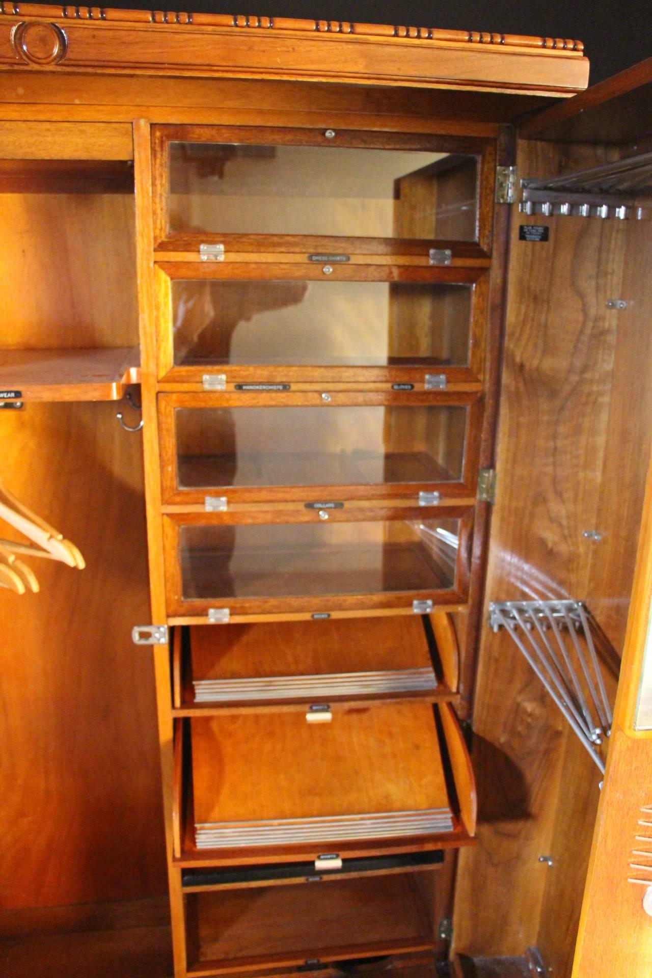 This closet is perfectly fitted inside. On the left hand side, it has got an articulated hanging section and a shelf.
 On the right hand side it has got a series of four glazed compartments, two sliding trays for shirts fitted with separators and