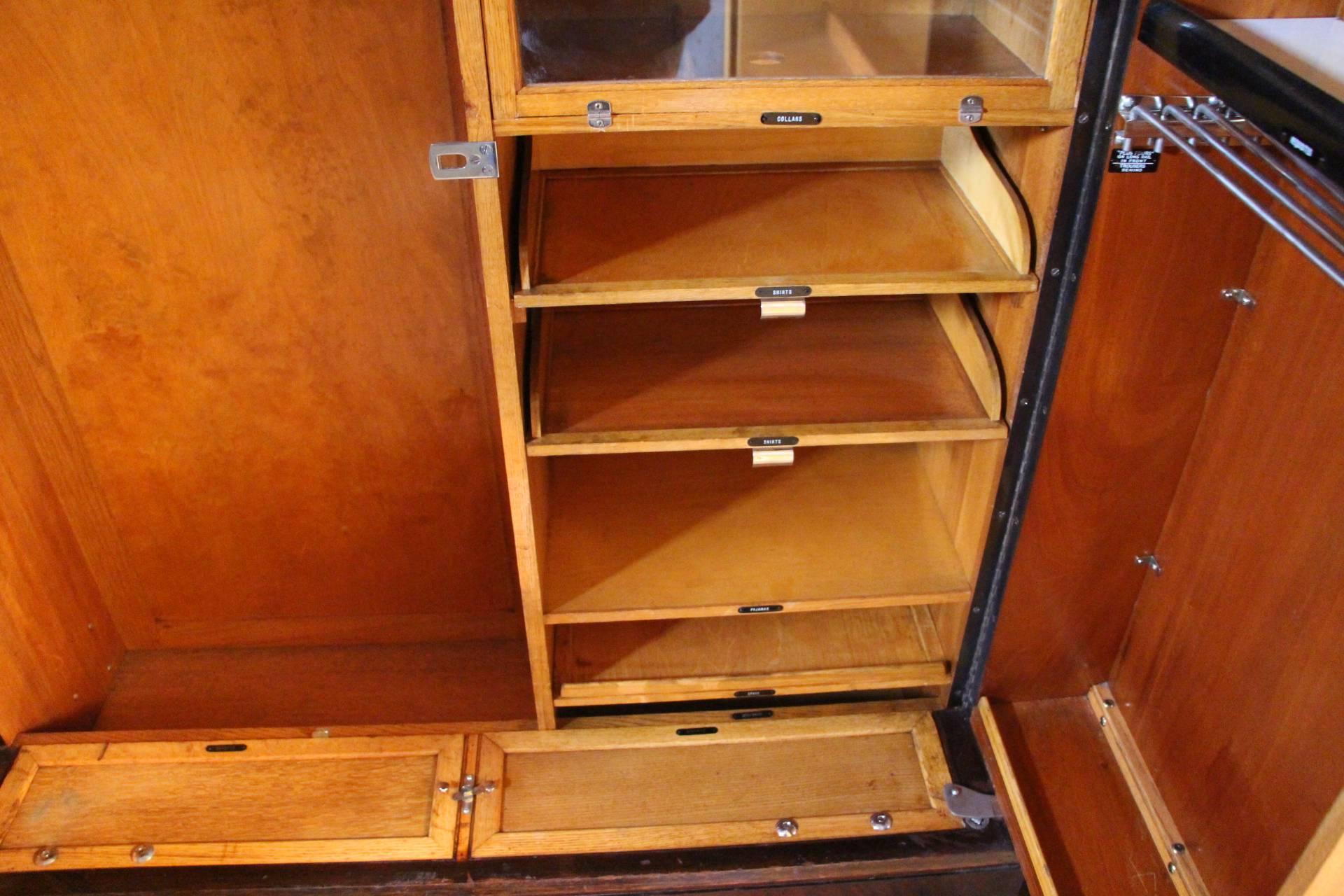 This closet is perfectly fitted inside. On the left hand side, it has got an articulated hanging section for 12 hangers and on the right hand side it has got a series of four glazed compartments, two sliding trays for shirts and two shelves.
Inside