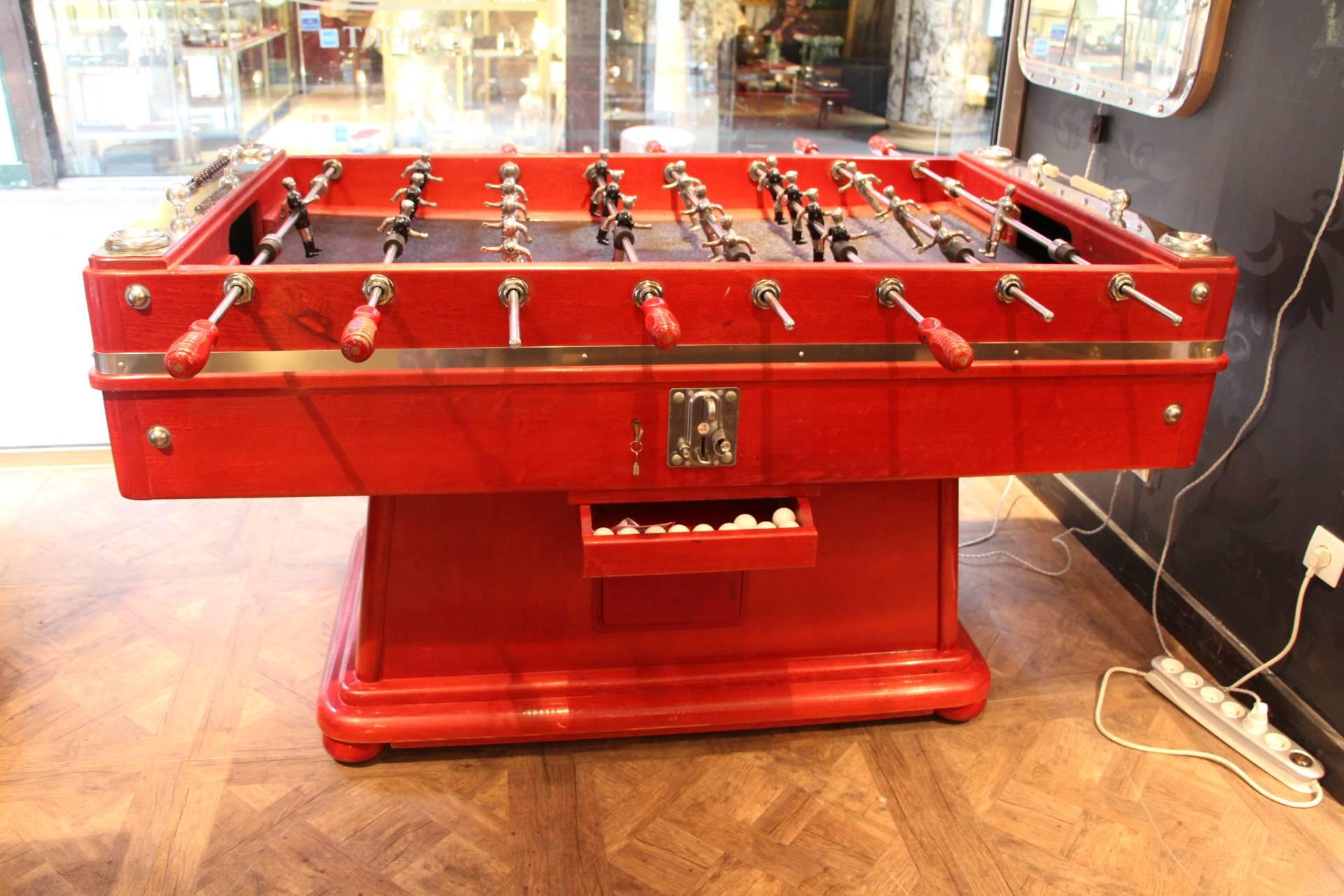
This foosball table is very impressive due to its size and to its cast metal polished players that have two legs and two arms instead of only one block.
Original red lacquer finish.
Moreover, thanks to its sloped paying surface, the ball is