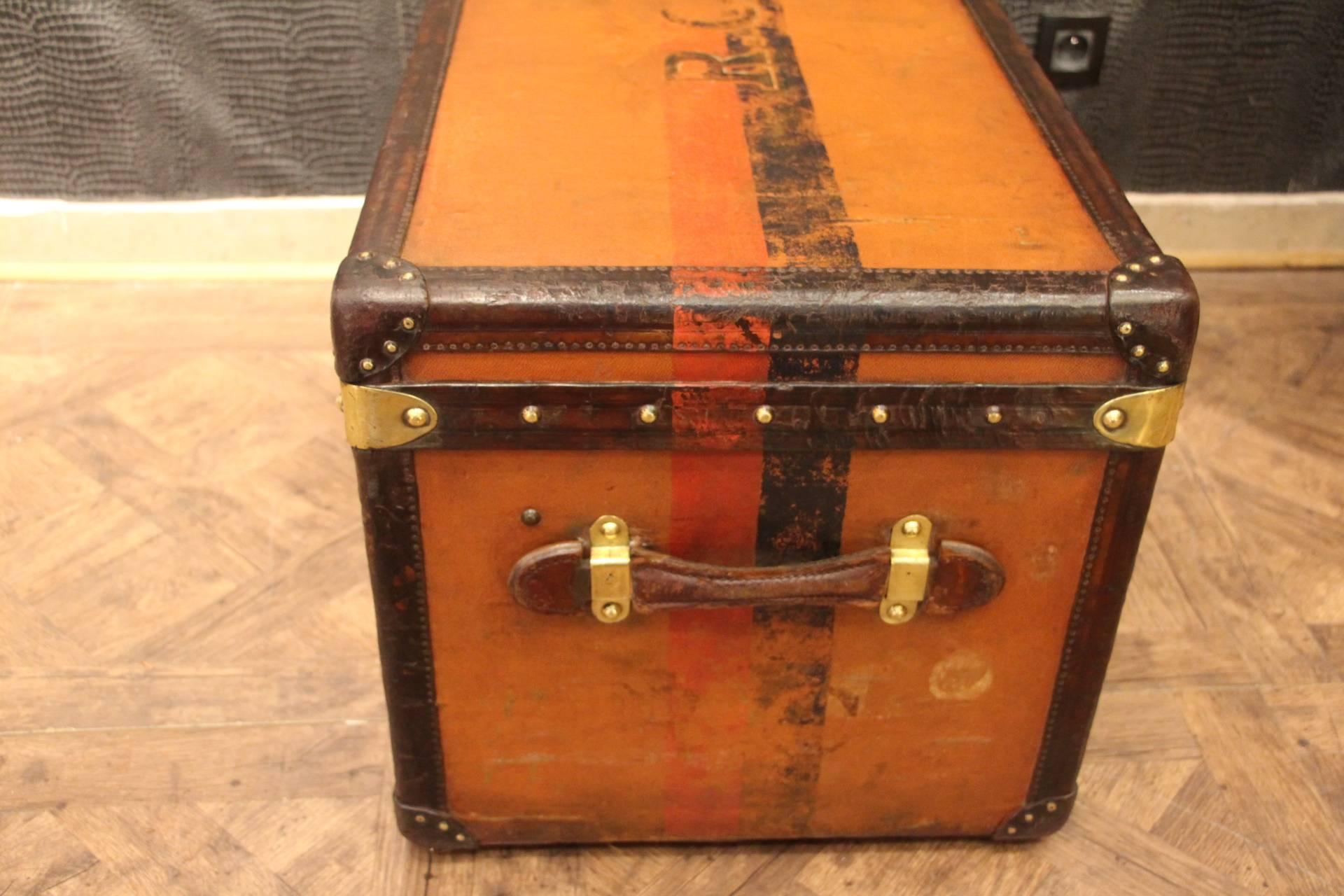 This beautiful little orange Louis Vuitton steamer trunk features leather trim and side handles, as well as brass locks and stamped studs. It has got a deep and warm patina.
Its interior is all original too except its lid that has been perfectly