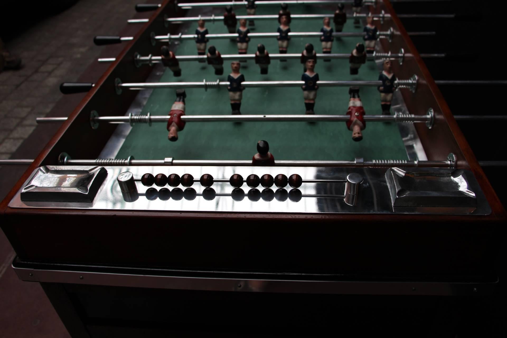 This very chic French beechwood and ebonized foosball table on shaped support has got red and blue carved wood players as well as its original green 