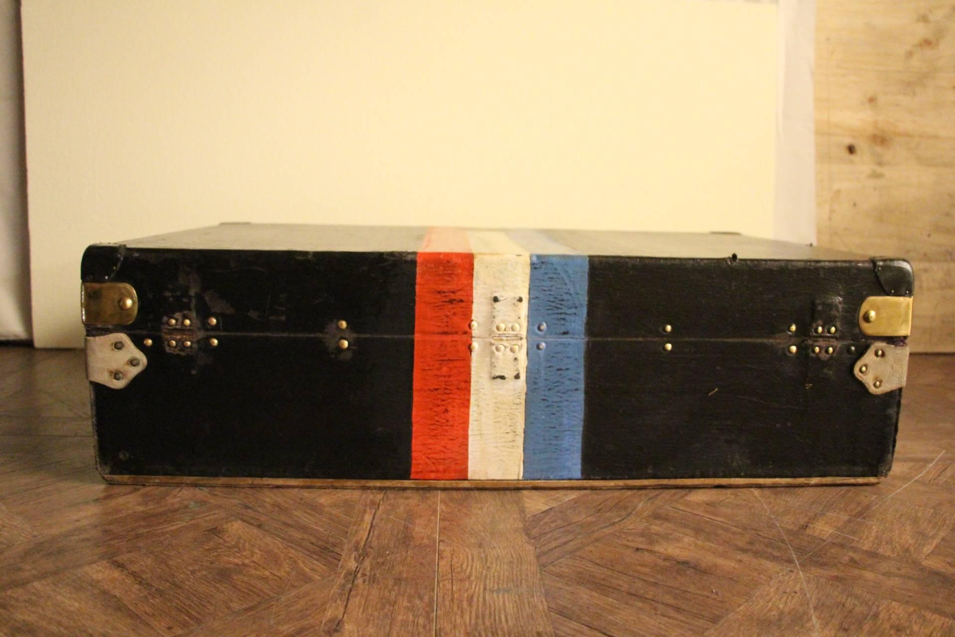 This very nice Louis Vuitton auto trunk in black canvas, features French flag colors, brass locks, stamped LV studs, leather side handles and many travel tags. It steel has got its original LV plaque on the side.
Its interior is all original with