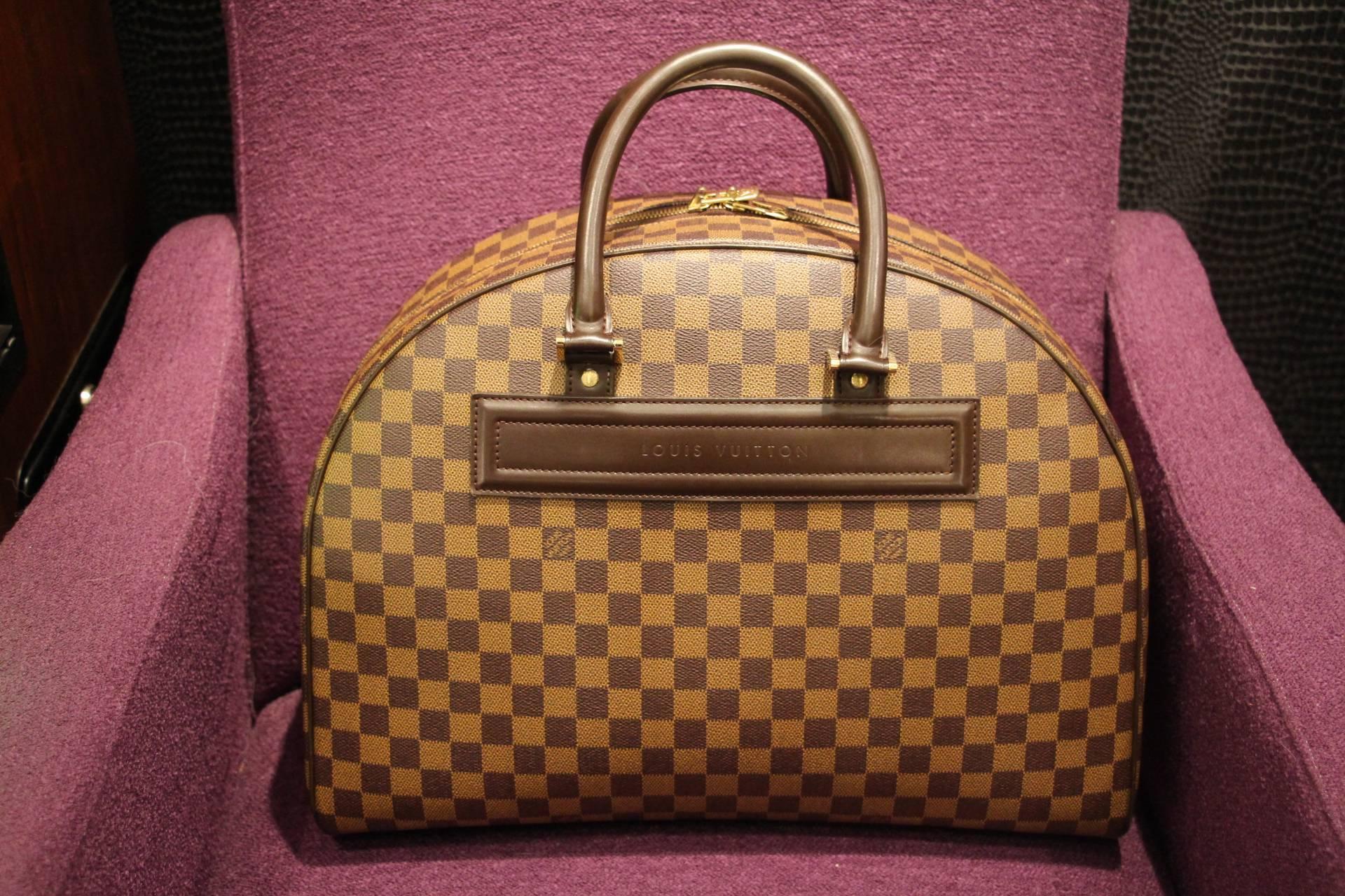 This extra large Louis Vuitton travel bag features leather handles and damier canvas. It has a pocket on one side.
Its interior is all orange coral canvas with a pocket.
As it is no longer sold in Louis Vuitton stores in this size, it is now a
