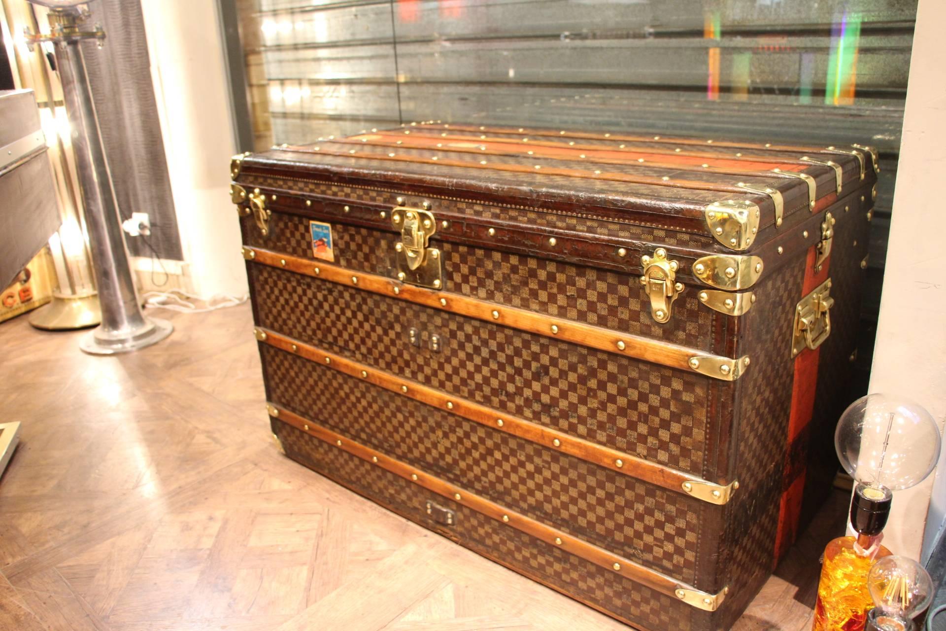 This spectacular Louis Vuitton steamer trunk features the very sought after checker pattern canvas, leather trim and all stamped brass fittings: Locks, clasps, side handles and studs. It is a genuine top of the range piece.
It has got a red painted
