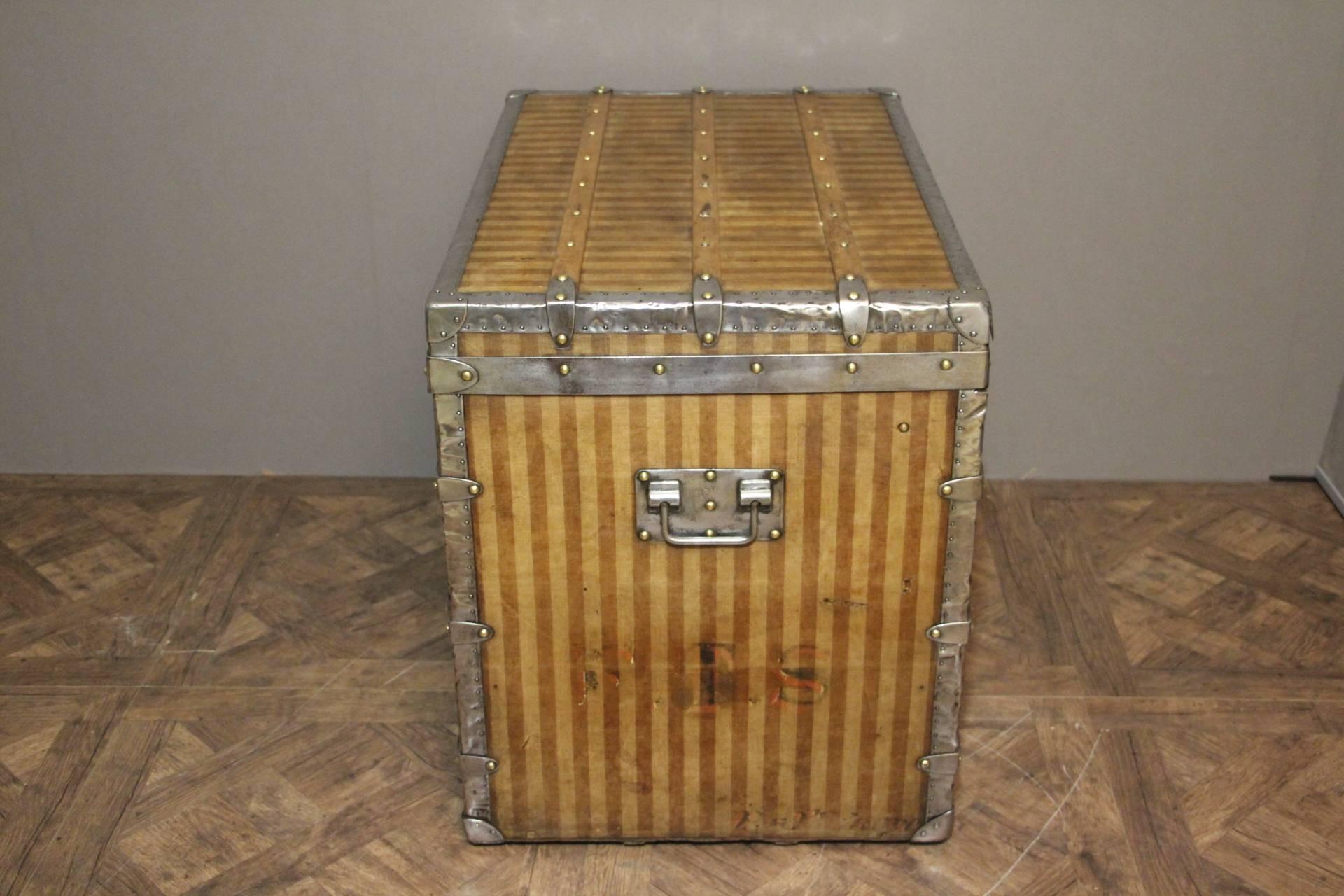 This antique Louis Vuitton steamer trunk features the very rare beige and brown stripped canvas as well as its brass main lock, its two steel latches and LV marked steel side handles.

All its steel pieces have been restored to a wonderful