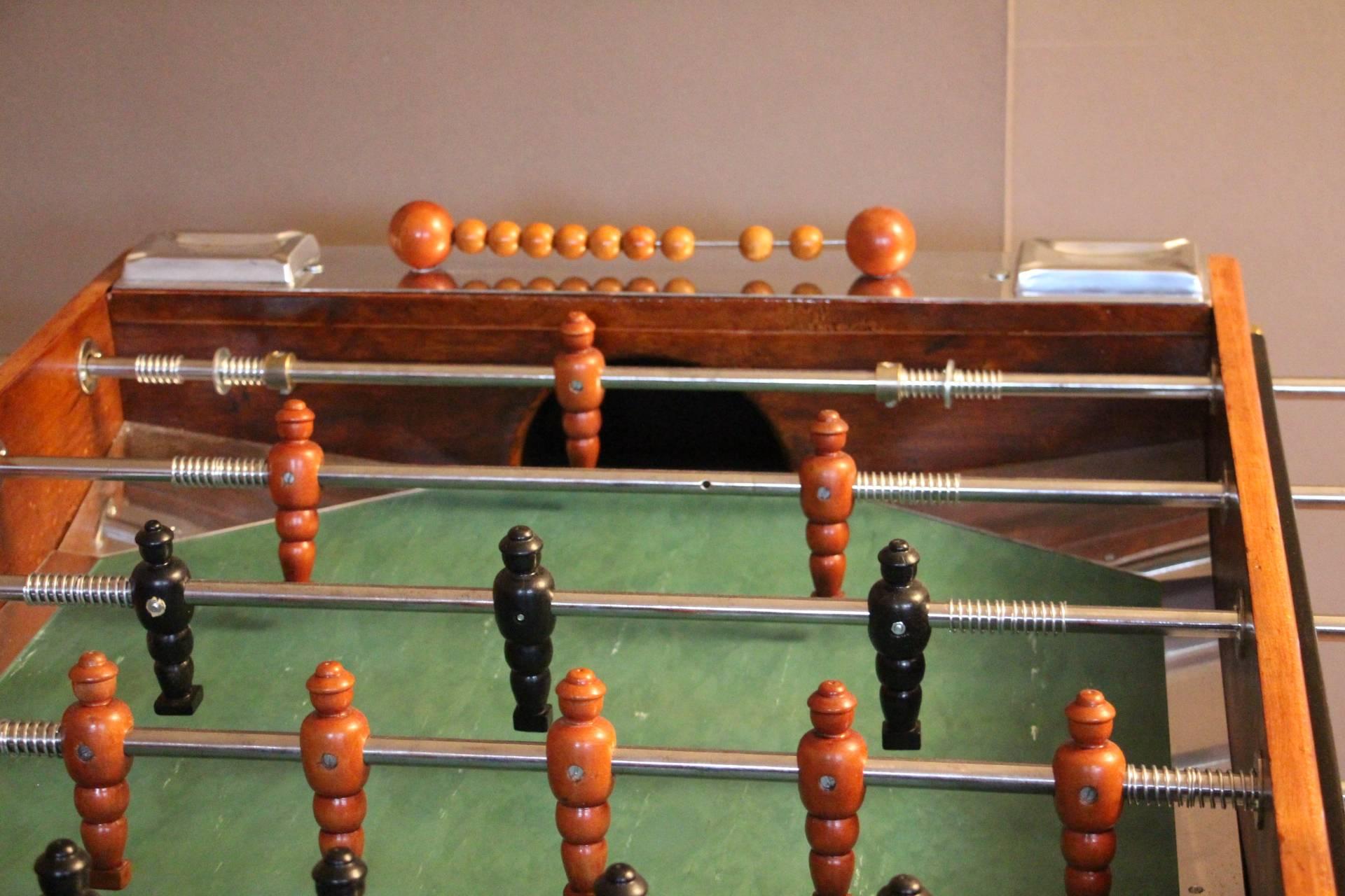 Mid-Century French foosball table
Unusual shape of French foosball table, this item is spectacular. It is in light color wood and blackened wood and features many aluminium pieces. Its players are in carved wood. Original green field and four