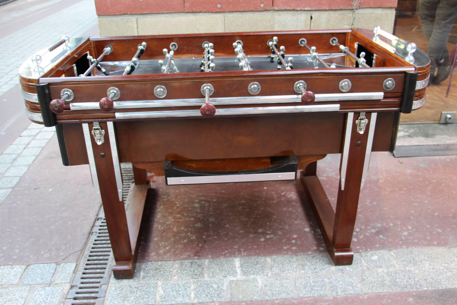 This wonderful foosball table features brown and black wood as well as many pieces of polished aluminium.
Its players are in polished and black aluminium.
Black playing 