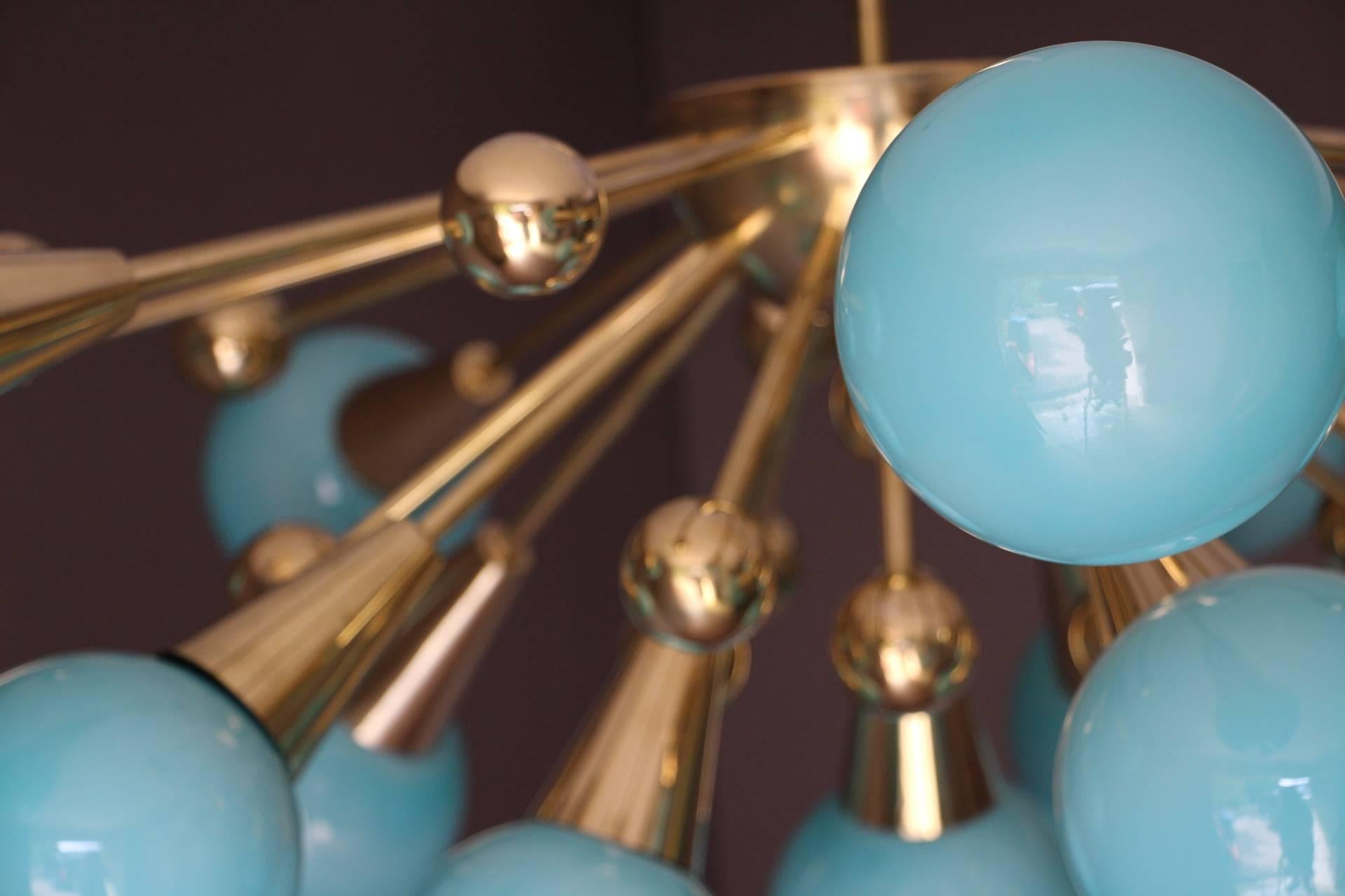 This brass chandelier features 15 turquoise blue Murano glass globes and 15 brass balls extends on brass stems from its centre.
When light is on, its turquoise globes turn to light blue color.
Unusual dimensions: Only 70 cm height and 110 cm