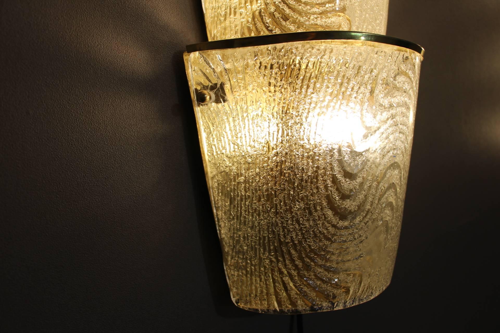 This wonderful pair of glass sconces features frosted graniglia Murano glass and brass. Very unusual design. It has got the shape three champagne buckets. Nice and warm light.
Many 46 reflects on the wall as we can see on the 1st photo.