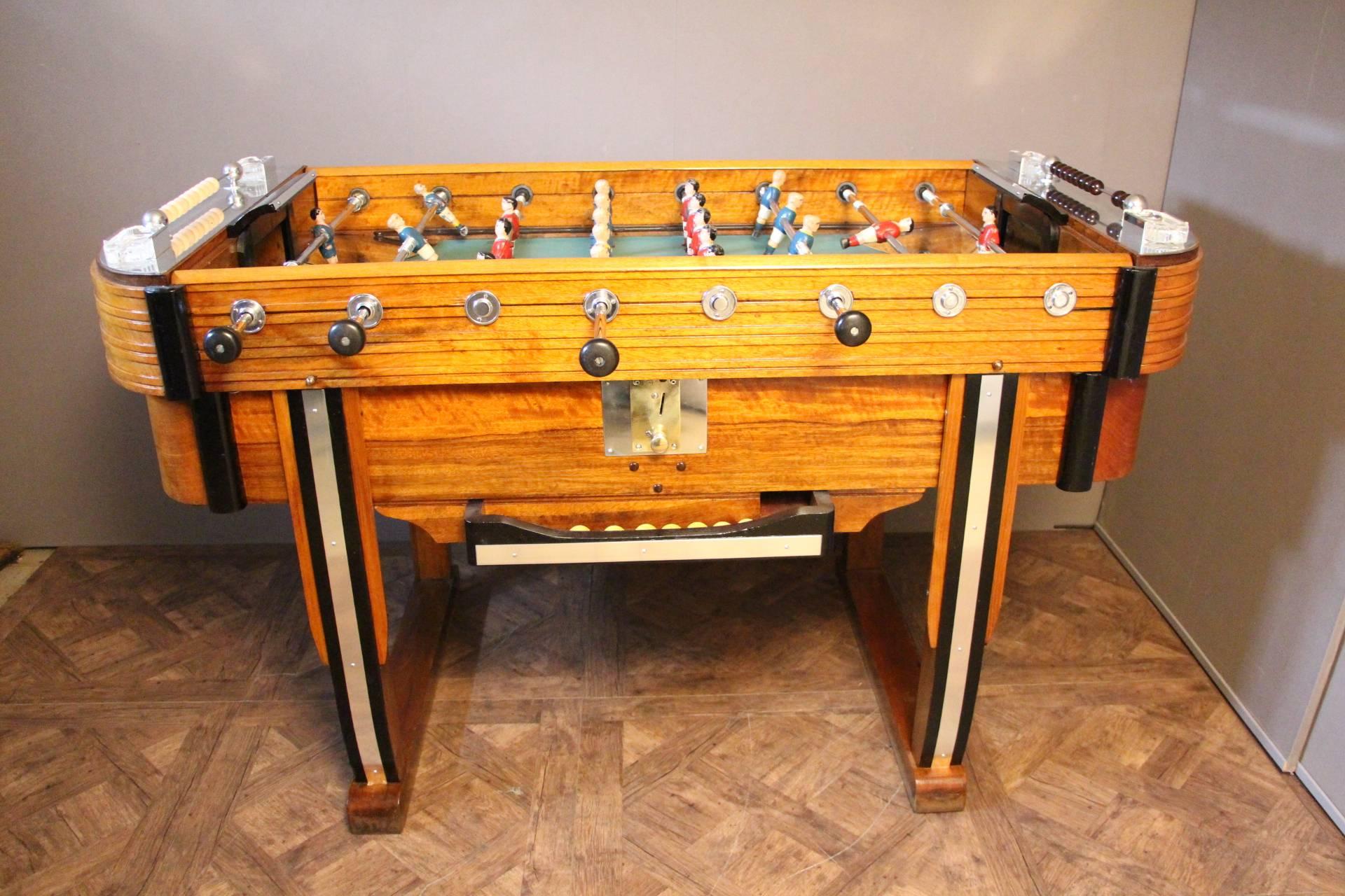 Very nice foosball table in light color wood and blackened wood as well as polished aluminium pieces.
Green playing field, blue and red players. Four crystal ashtrays by Lalique.
Working coin operating.
It is in perfect working order and moreover