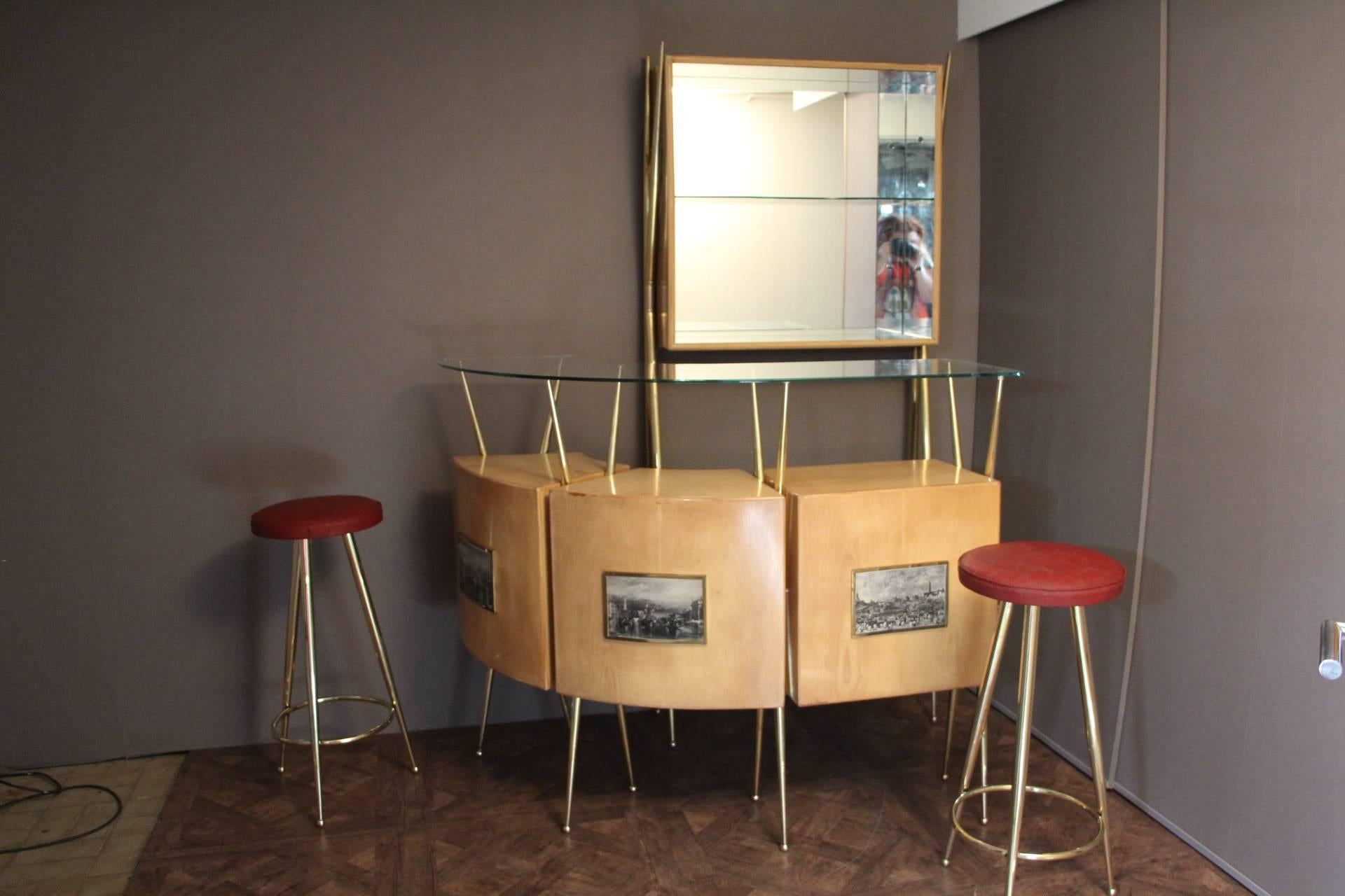 This very chic and complete bar cabinet consists of one high wall-console, one curved serving cabinet and two brass stools with original red moleskine top.
The brass base of the console and the cabinet gives a very elegant style to the set.
Full