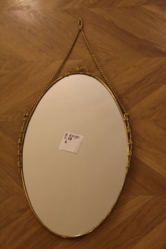 1950's Oval Brass Wall Mirror with Neoclassical Decoration And Rigid Brass Chain