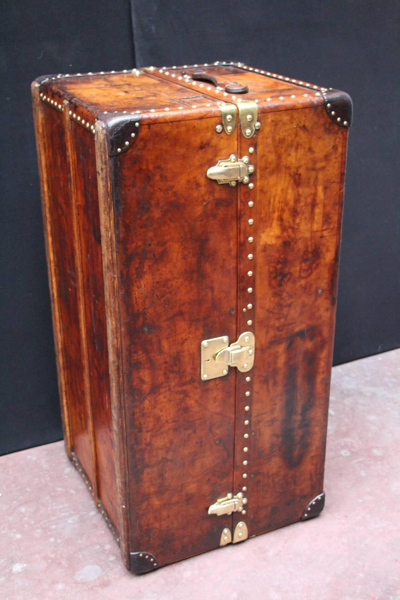 This very unusual Louis Vuitton trunk features a rich and very warm brown leather shaded patina. All stamped Louis Vuitton brass studs, lock and latches. Original leather handle.
Once open, it reveals two folding hanging sections with many LV