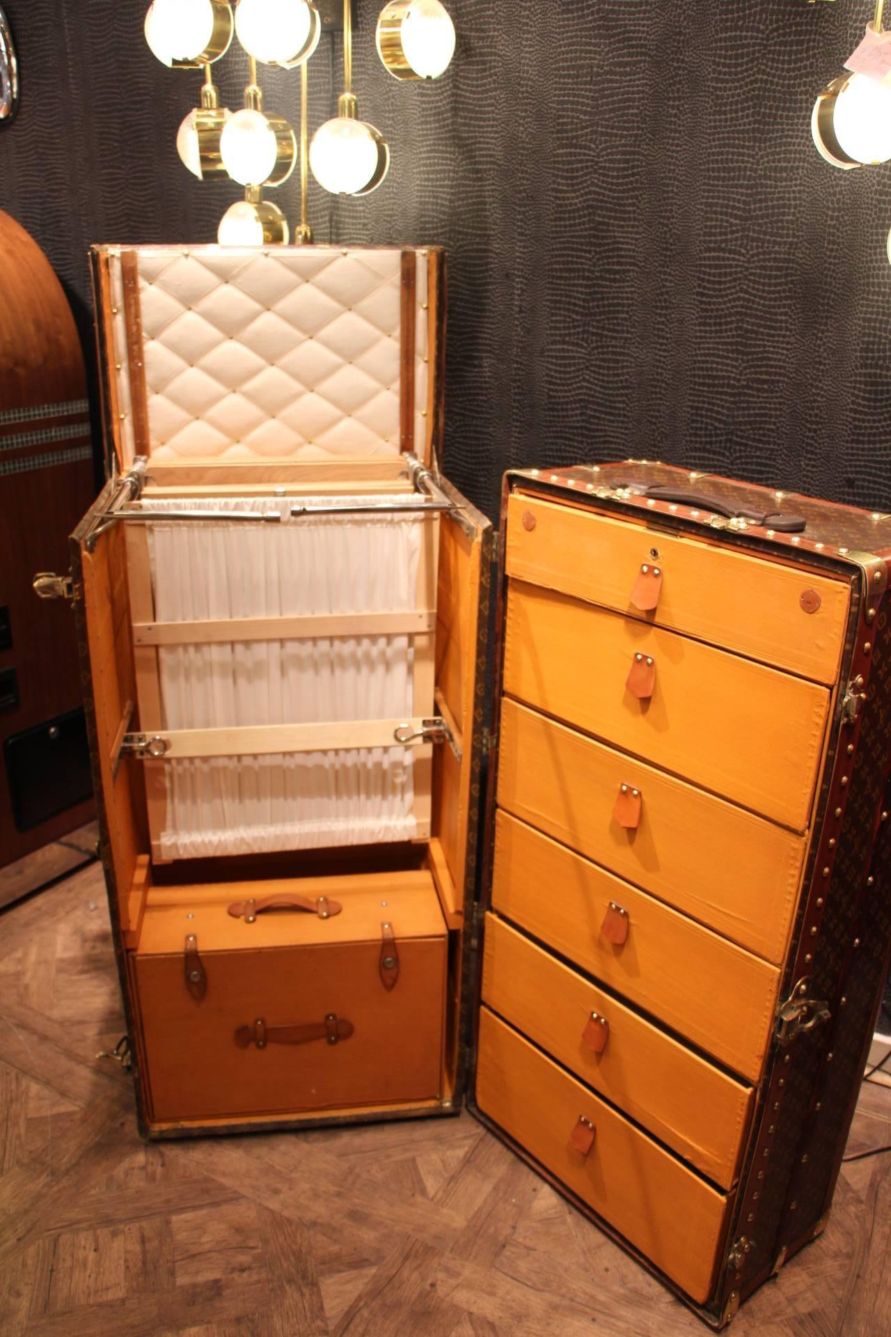 This impressive Louis Vuitton wardrobe features stenciled monogramm canvas, lozine trims, brass LV stamped locks and studs as well as its lift top. It has got a beautiful warm patina.
Its interior is complete with its original hangers, its