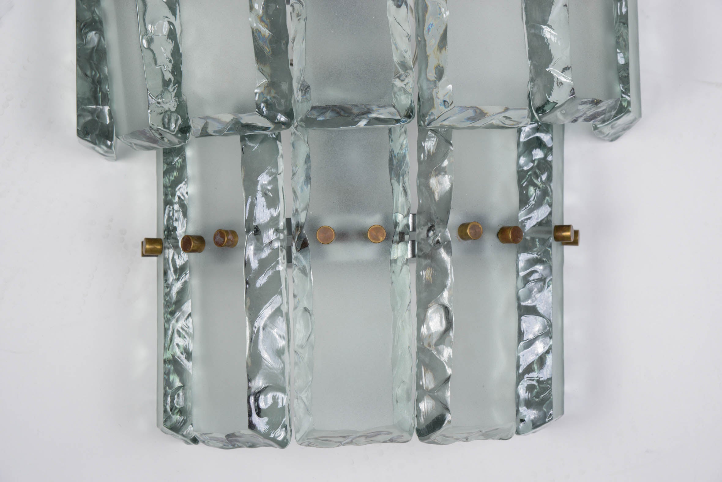 Ten wall sconces made of two rows of ground glass pieces each with hand chiseled edges, hold by a metal structure. In the style of Max Ingrand for Fontana Arte.