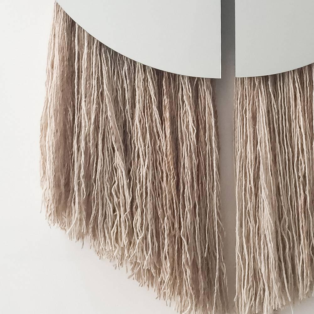 The Apollo Mirror by Ben and Aja Blanc combines the functionality of a large sized mirror with the depth and textural interest of sculptural fiber.

