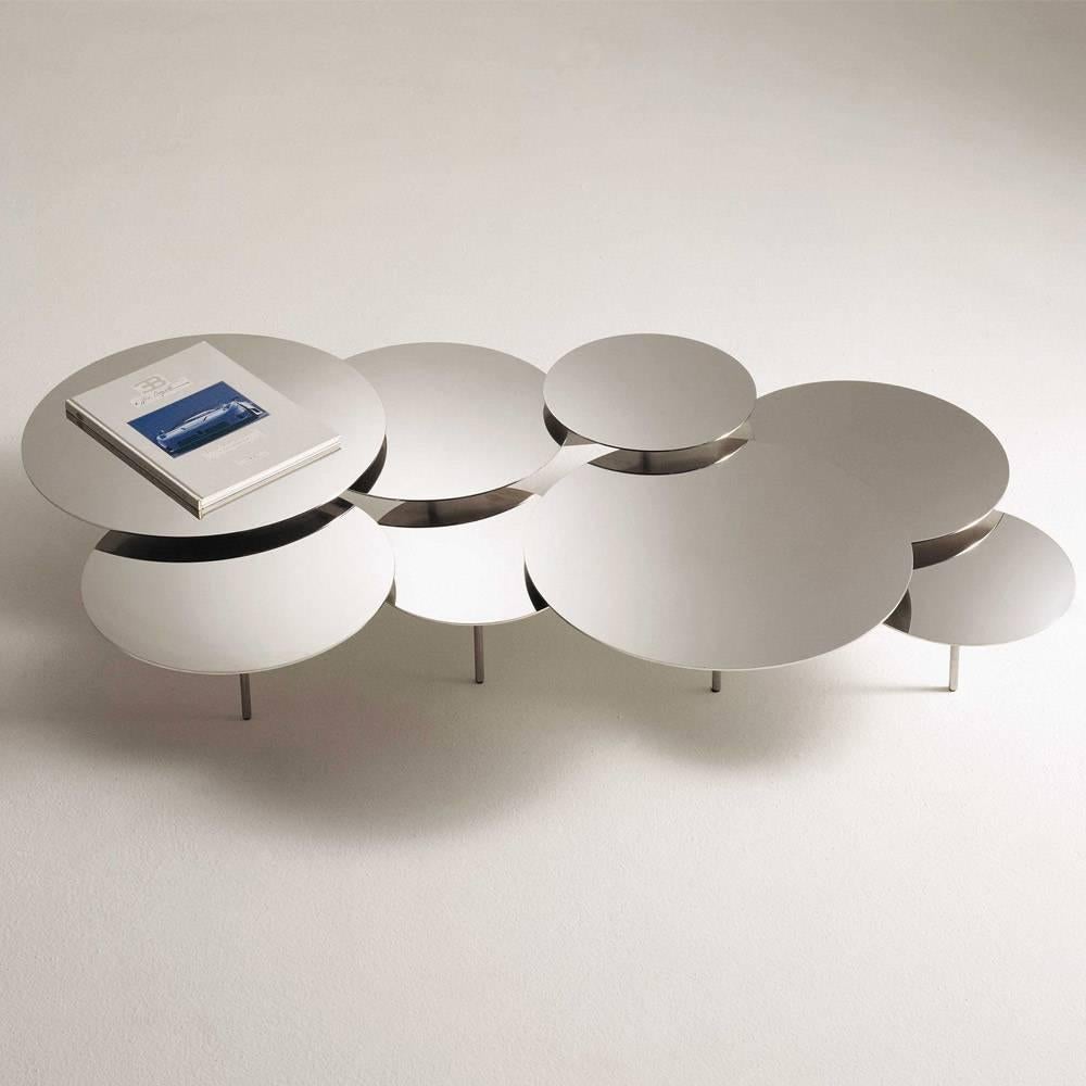 The snake coffee table is characterized by its composition of polished steel circular table tops of various diameters. The various diameters of the composition are mounted at different heights on individual frames linked together, enabling the