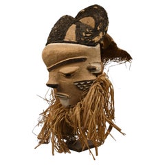 Pende mask with textile headdress and plant fiber beard, first half 20th century