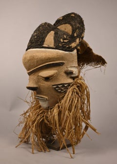 Pende mask with textile headdress and plant fiber beard, first half 20th century