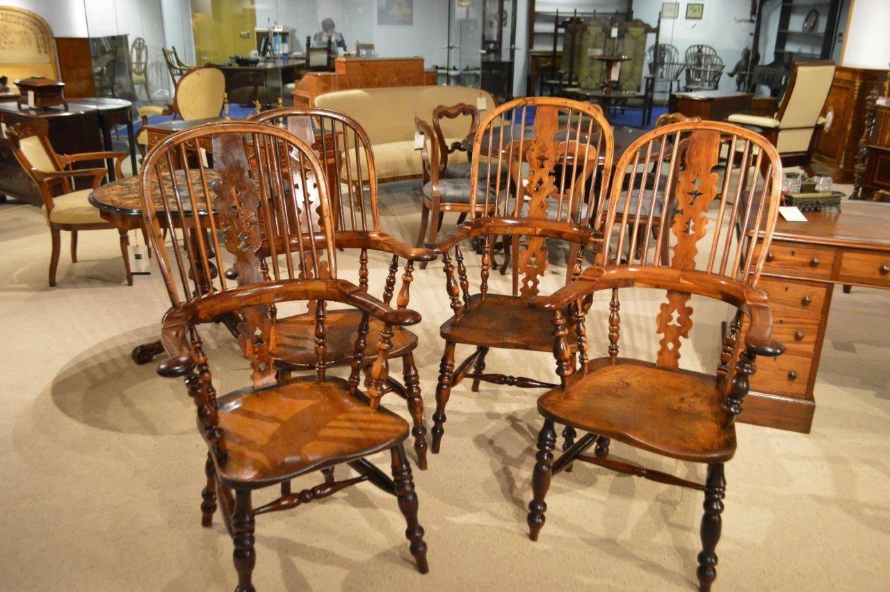 A wonderful set of 4 yew wood broad arm windsor armchairs. Each chair having a traditional hooped back with 