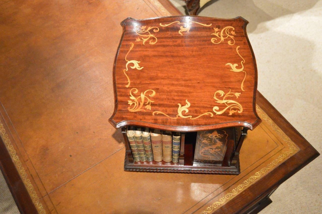 A small mahogany inlaid Edwardian Period revolving table bookcase by Shapland & Petter Of Barnstaple. Having a solid mahogany top of serpentine outline with foliate marquetry inlaid detail, supported on fine mahogany balustrade columns with four