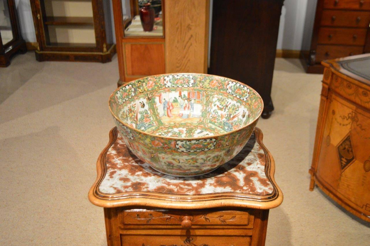 A large Canton Famille Rose punch bowl. Beautifully hand decorated internally and externally on gold ground with six panels, three depicting every day Chinese life and three with butterfiles and birds amongst foliage, also repeated on the interior.