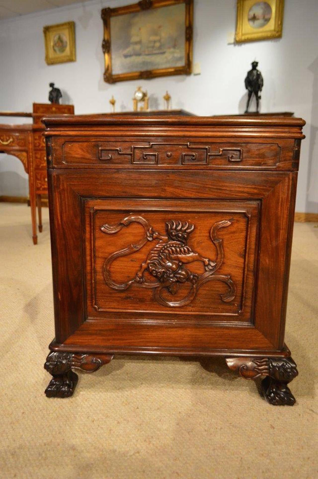 A hardwood Chinese carved camphor lined trunk. The hinged top having a wonderful rectangular carved panel depicting dragons at play within a typical Oriental carved border, opening to reveal a camphor lined interior. Having carved paneled ends, back
