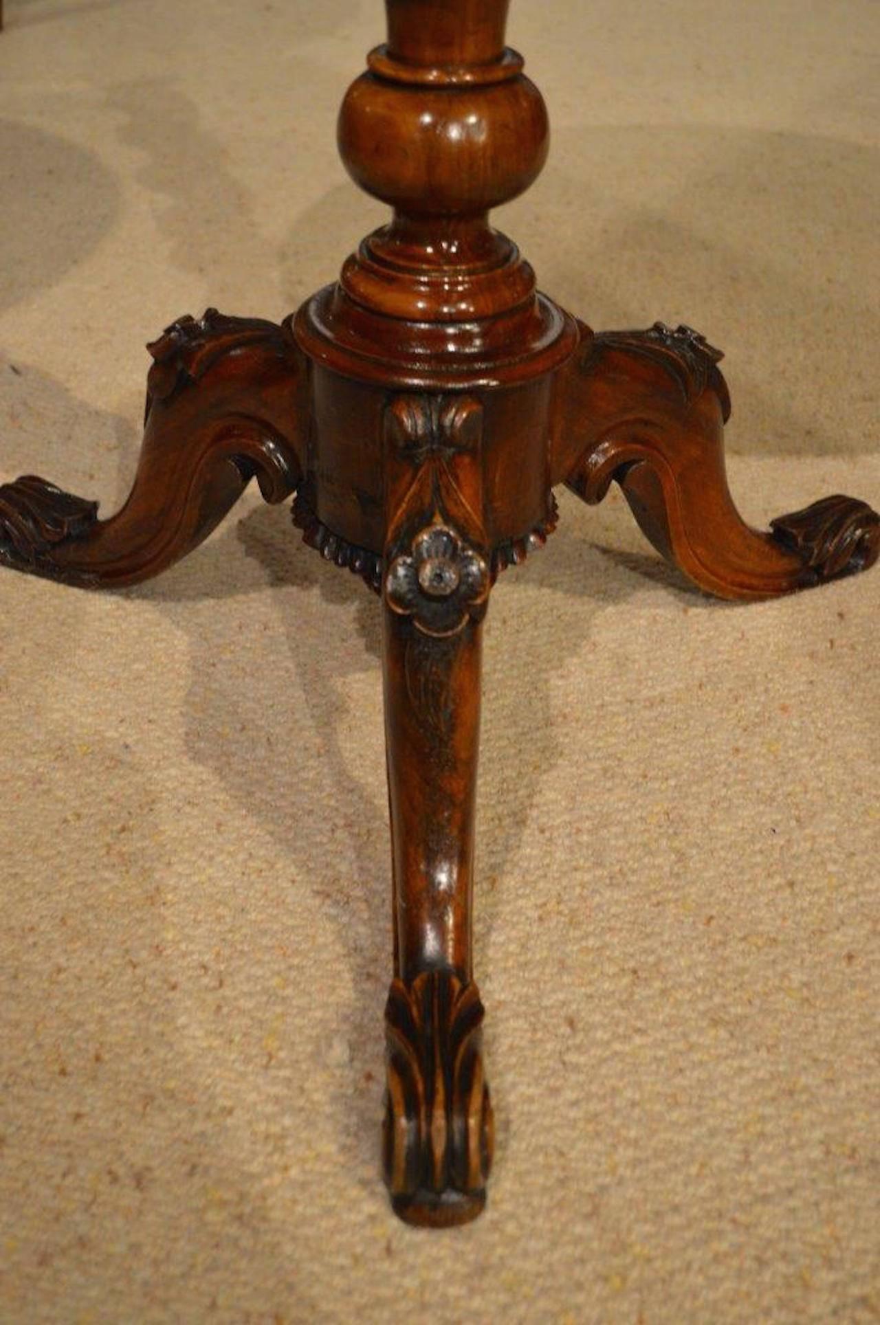 A burr walnut Victorian Period antique chess table. Having a circular top veneered in burr walnut and with a rosewood and birds eye maple veneered inset chess board. Supported on a spiral twist column with floral carved cabriole supports. English