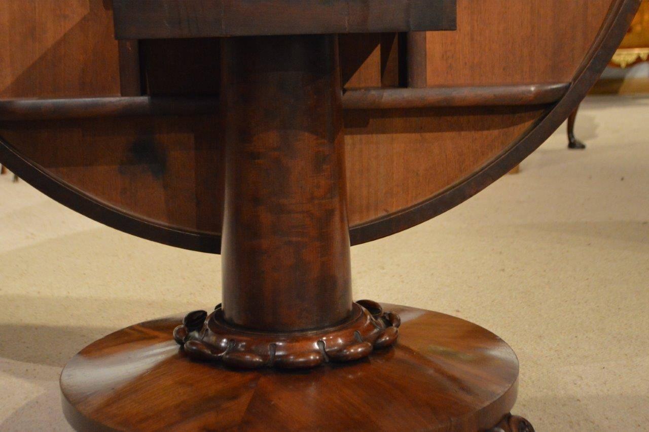 A good mahogany Early Victorian period circular loop/dining table. Having a circular top veneered in beautiful figured mahogany, supported on a bold figured mahogany column with a lobed collar on a circular platform, with carved cabriole feet and