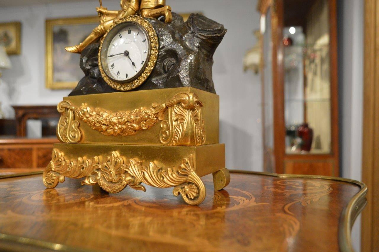 A bronze and ormolu-mounted mid-19th century period clock by Charles Frodsham of London. The bronze and ormolu case having gilt bronze knights on a naturalistic bronze rocky outcrop, with an ormolu base with swags and anthemions. The central