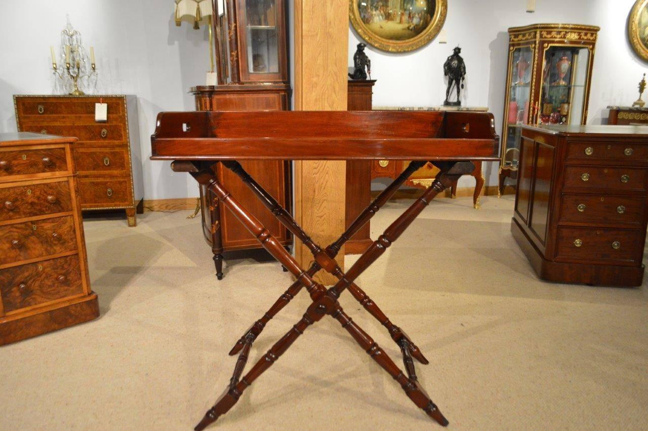 A fine quality mahogany early Victorian period butlers tray on stand. Having a traditional removable butlers tray with a shaped gallery and pierced handles, constructed using the finest mahogany. Supported on an X-framed turned mahogany stand,
