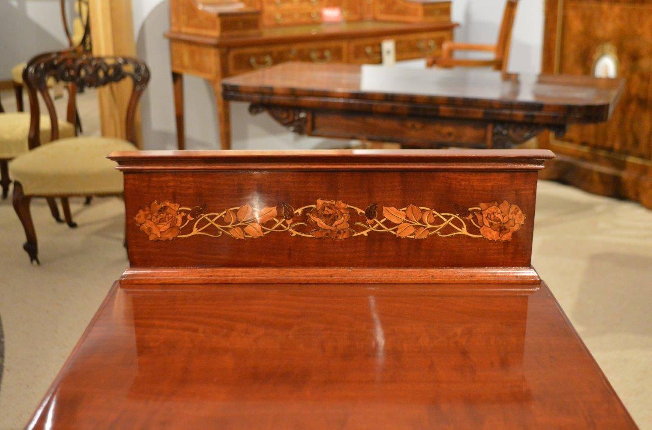 A good pair of Liberty & Co Edwardian period mahogany inlaid bedside cabinets. Each having a marquetry inlaid gallery above a solid mahogany top. The marquetry inlaid doors open to reveal shelved interiors with solid mahogany sides and supported on