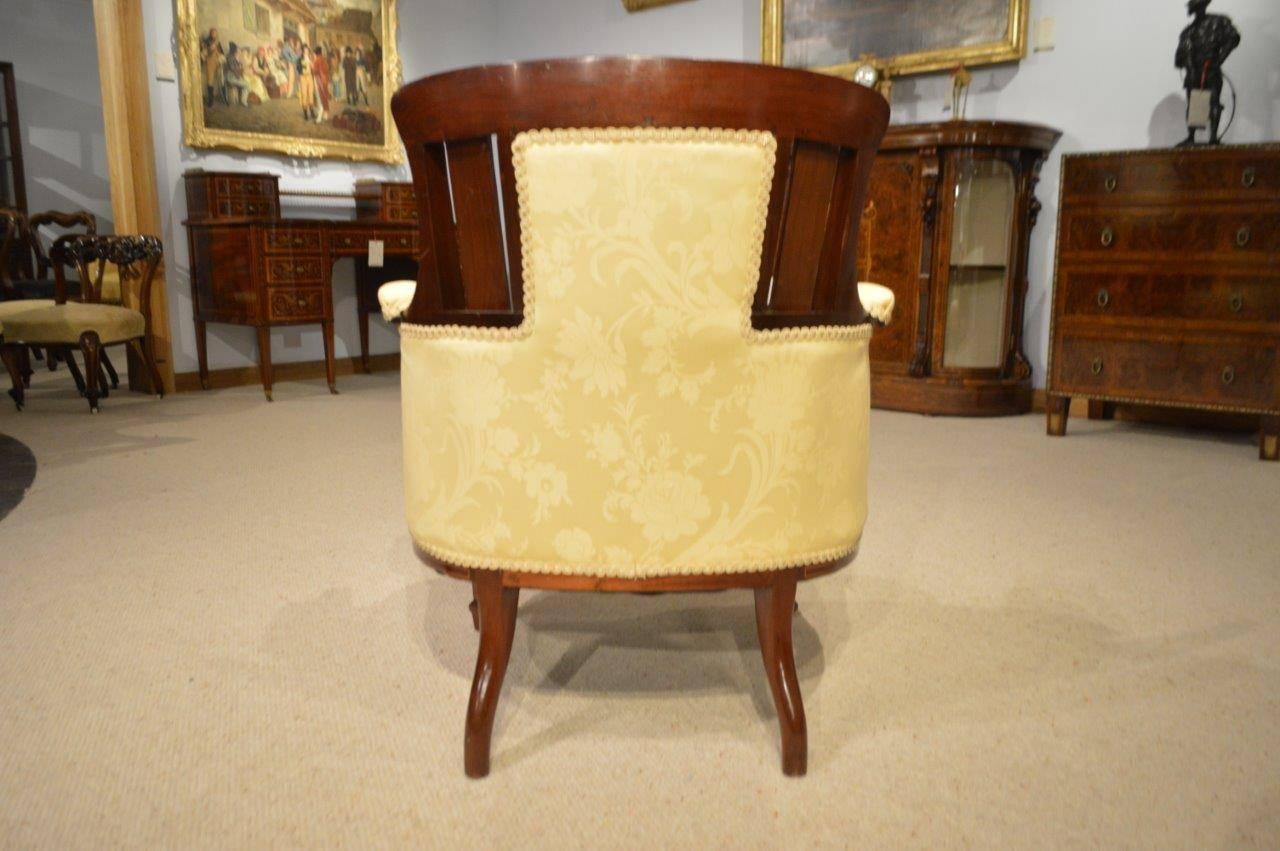 A mahogany and marquetry inlaid Edwardian period antique tub chair. Having a shaped 