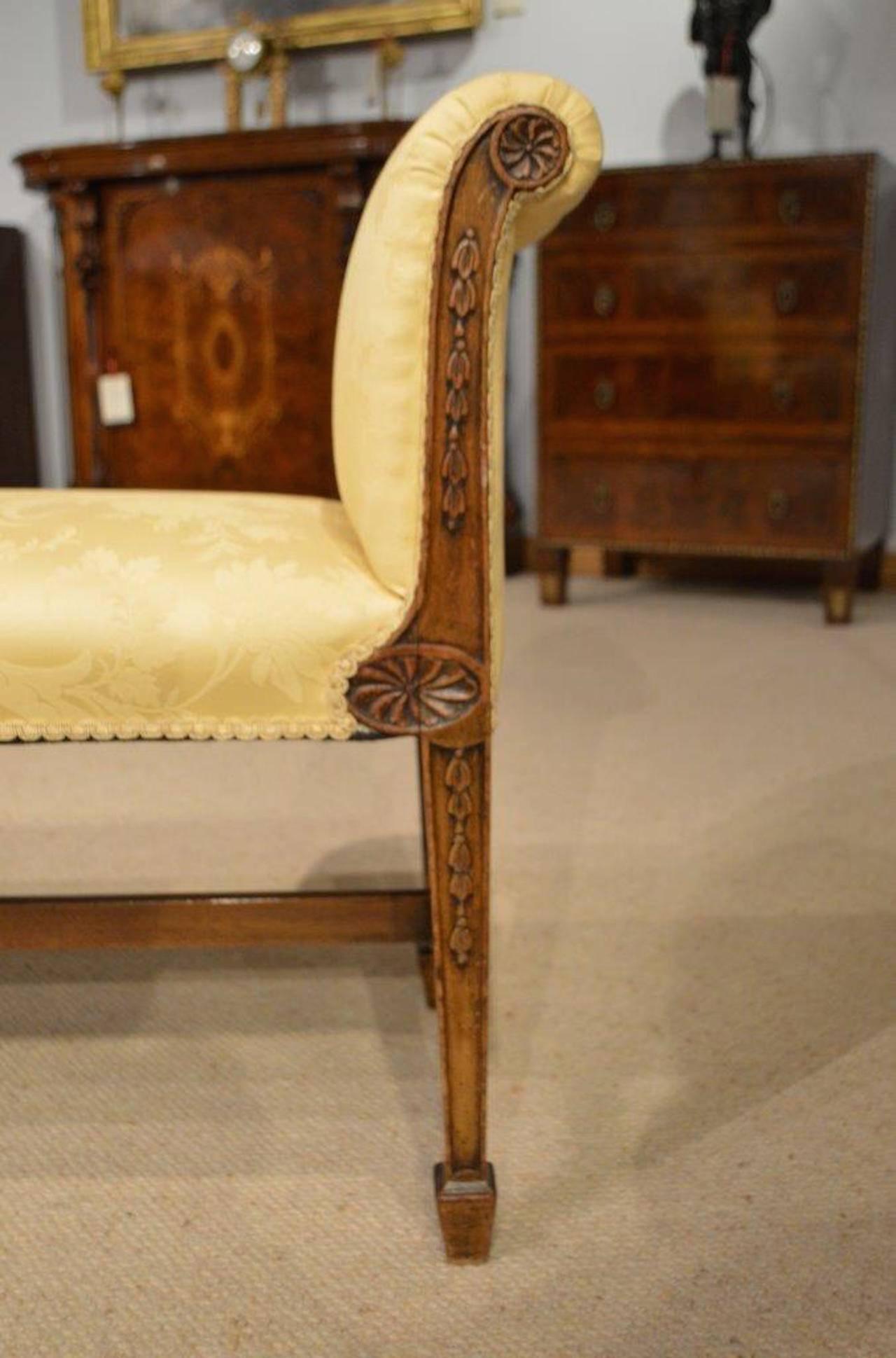 A mahogany Edwardian period "Adam designed" antique window seat. Having shaped ends with carved shell paterae and trailing harebells after an original design by Roberts Adams used, circa 1770-1780. Having padded arms and seat newly