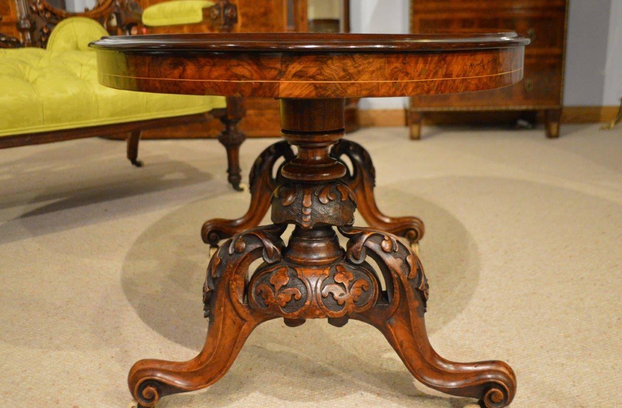 A burr walnut and marquetry inlaid Victorian period antique coffee table (adapted). The beautifully figured burr walnut top having fine boxwood foliate marquetry detail and supported on a floral carved and turned baluster stem with acanthus carved