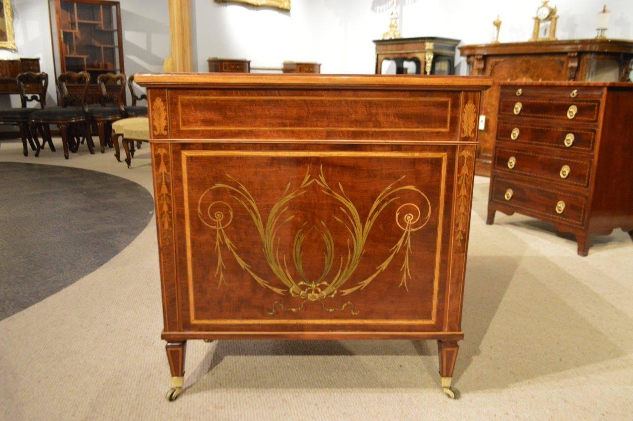 A fine quality marquetry and pen-work inlaid Sheraton Revival antique writing desk by Edwards & Roberts of London. Having a rectangular top with a fine marquetry floral border and an olive green inset leather writing surface with blind and gilt