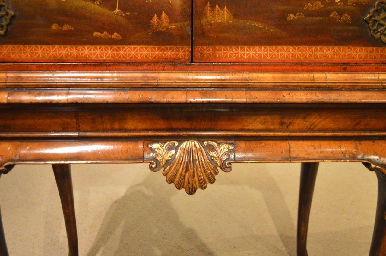 A fine quality chinoiserie and red lacquer antique cocktail cabinet. The upper cabinet section with red ground and polychrome lacquer detail depicting oriental life and the sides having mythical birds. The finely engraved brass hinges and