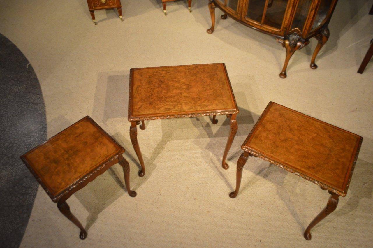 Antique burr walnut nest of tables. Each table having a burr walnut veneered top with floral carved moulding and raised on four acanthus carved cabriole legs with pad feet. English, circa 1920.

Condition: This nest of tables are in excellent