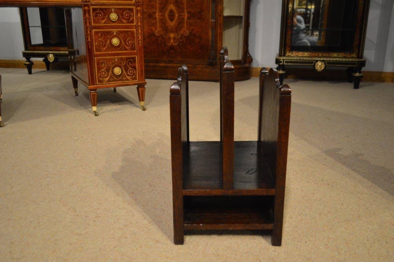 An oak Arts & Crafts period magazine rack possibly by Liberty's. With three divisions the central one having a pierced squashed heart handle. The outer ones with Voysey inspired heart shaped motifs, very much in the manner of Liberty's of London and