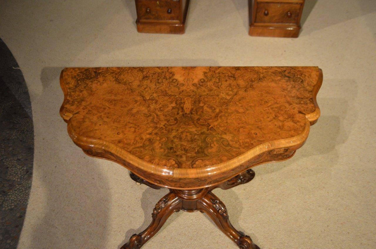 A burr walnut Victorian period antique fold over card table. The top of serpentine outline is veneered in beautifully figured burr walnut, swivels and opens to reveal a baize lined playing surface with a burr walnut border. Supported on an acanthus