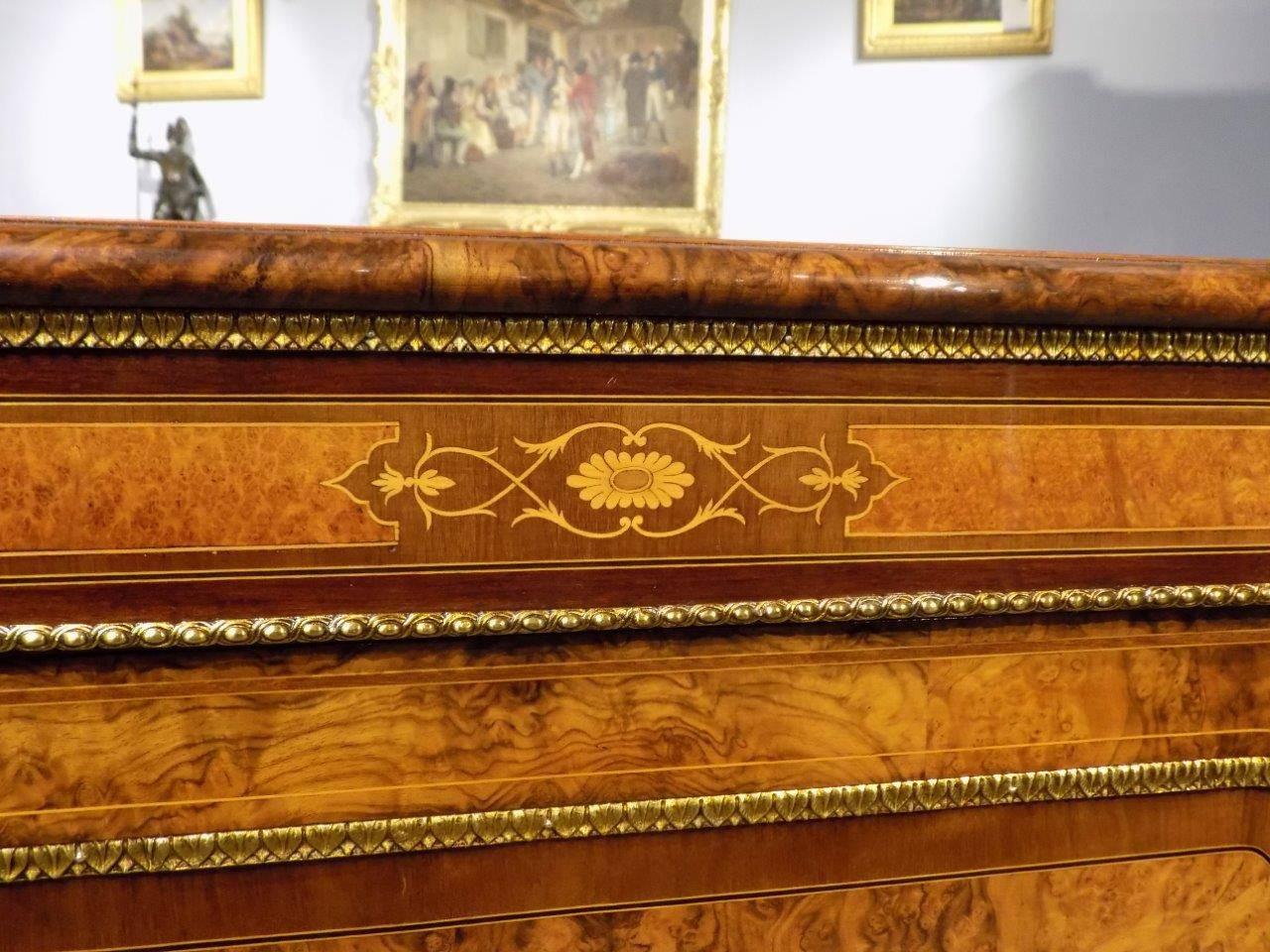A fine quality burr walnut and ormolu-mounted inlaid Victorian period credenza. Having a shaped top veneered in beautifully figured burr walnut with purple heart banding above an amboyna, purple heart, sycamore and marquetry inlaid frieze with