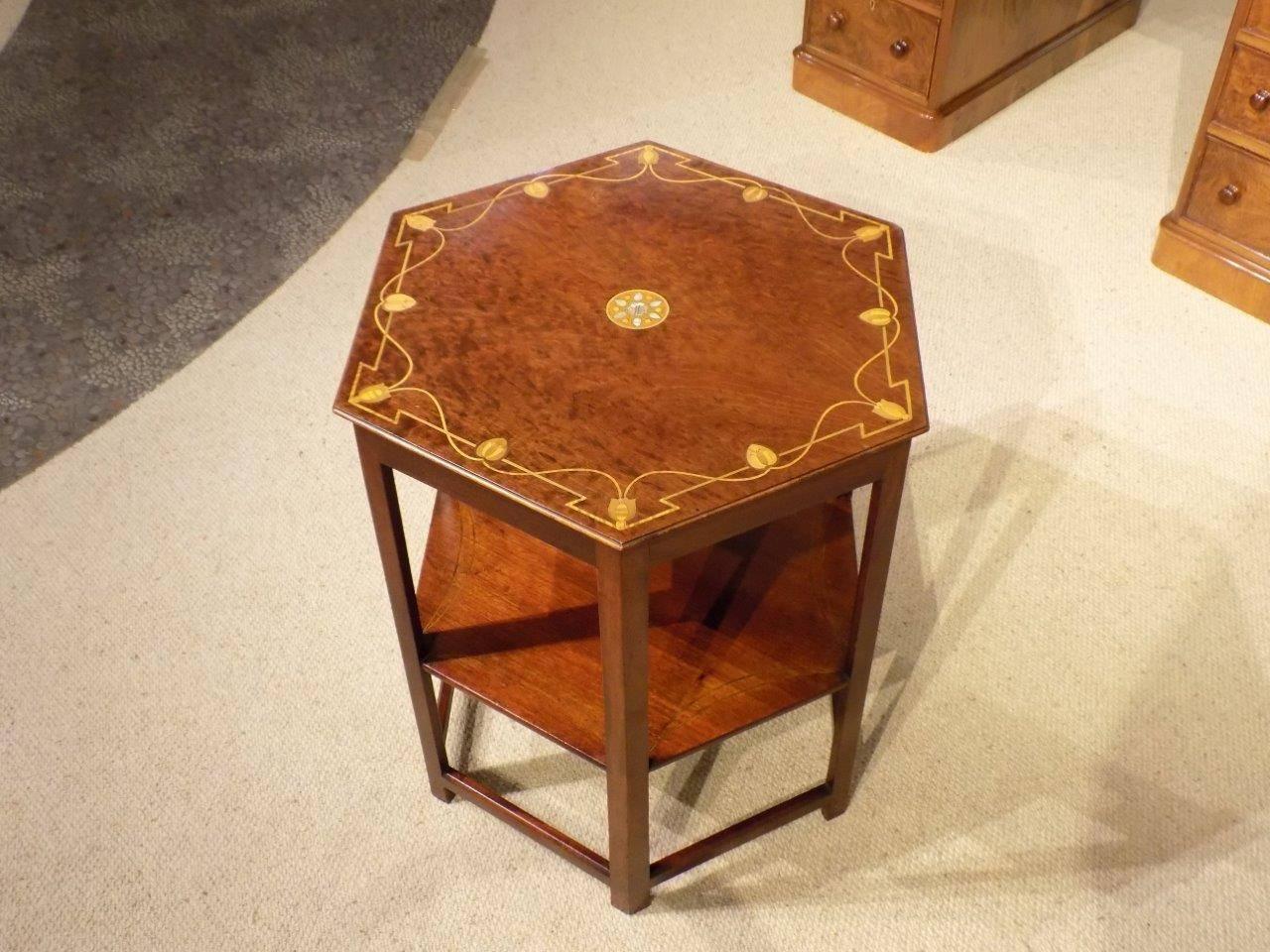 A mahogany Arts & Crafts period hexagonal inlaid table by Shapland & Petter of Barnstaple. Having a hexagonal top in solid plum pudding mahogany with a central marquetry mother-of-pearl inlaid roundel and a stylised floral marquetry inlaid