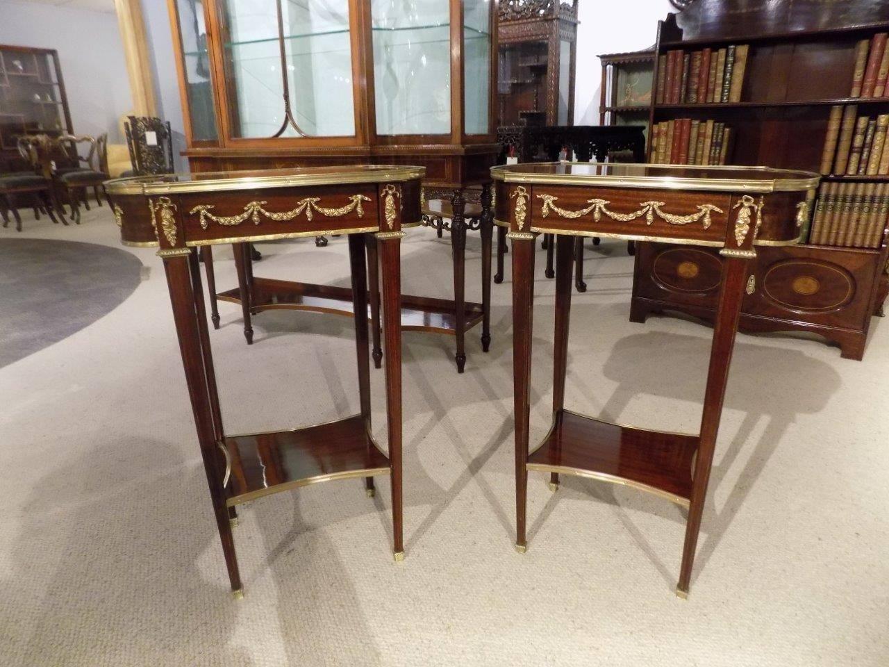 A fine quality pair of French mahogany, kingwood and parquetry inlaid late 19th century antique side tables. Each with a shaped top with a kingwood parquetry inlaid panel and mahogany and purple heart inlaid border with ormolu beading. Having a