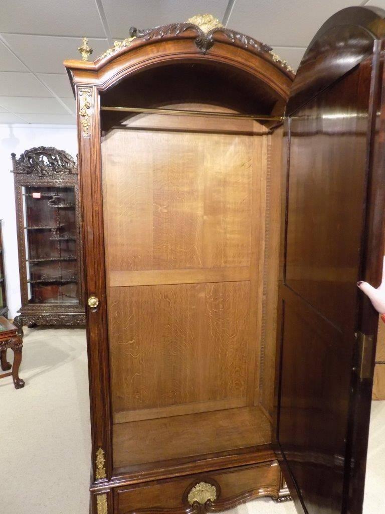 A fine quality French 19th century rosewood and ormolu-mounted armoire. Having a domed solid rosewood cornice with fine acanthus carved detail and surmounted with finely cast floral ormolu mounts and finials. The central arched door having a