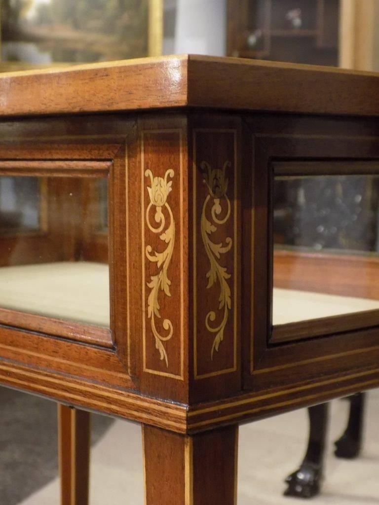A beautiful mahogany and marquetry inlaid Edwardian Period antique bijouterie cabinet. Having a rectangular glazed top with fine floral marquetry inlaid detail and opening to reveal a silk lined interior with four rectangular glazed viewing panels